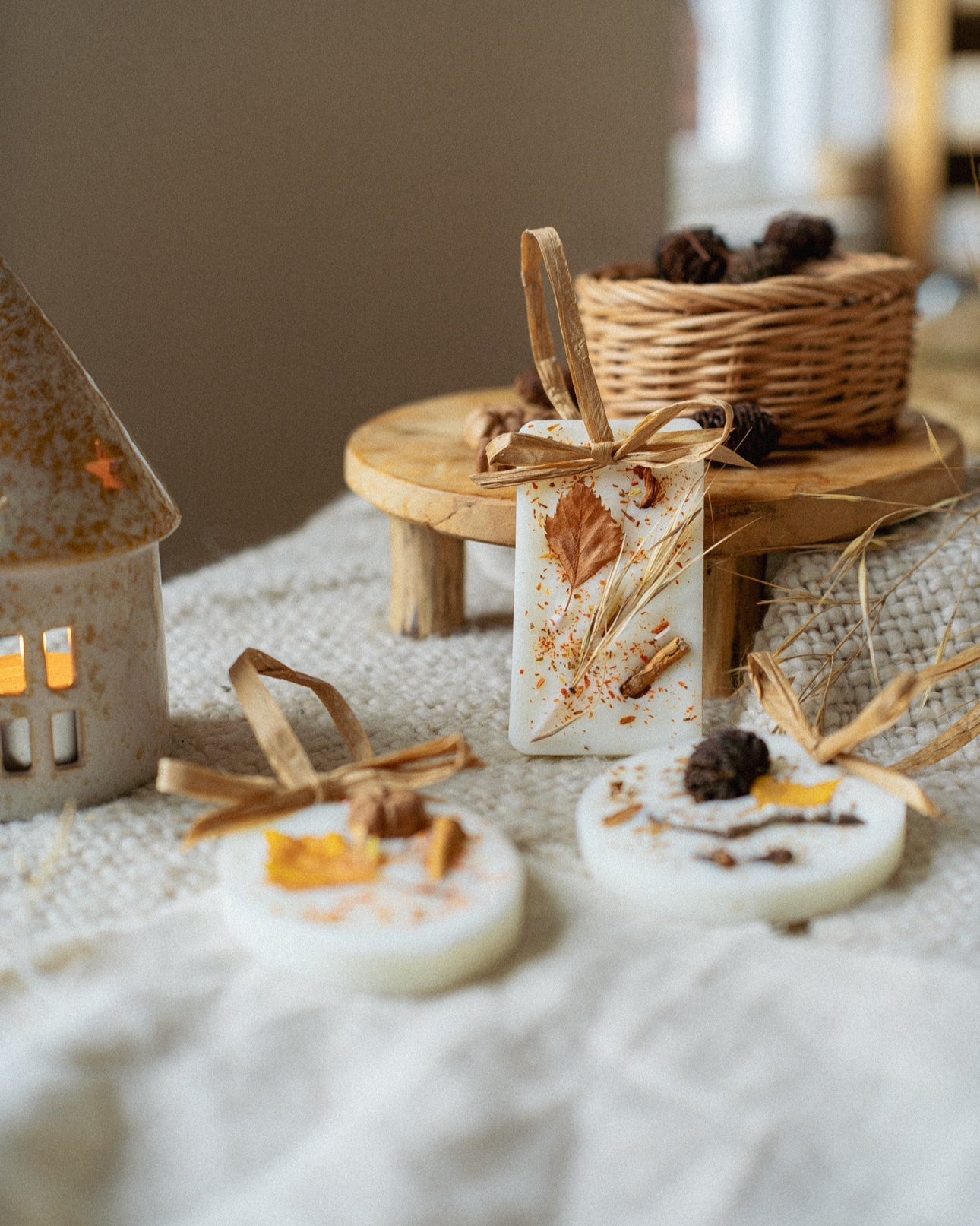 Decorative items on a textured surface with a basket and candle in the background