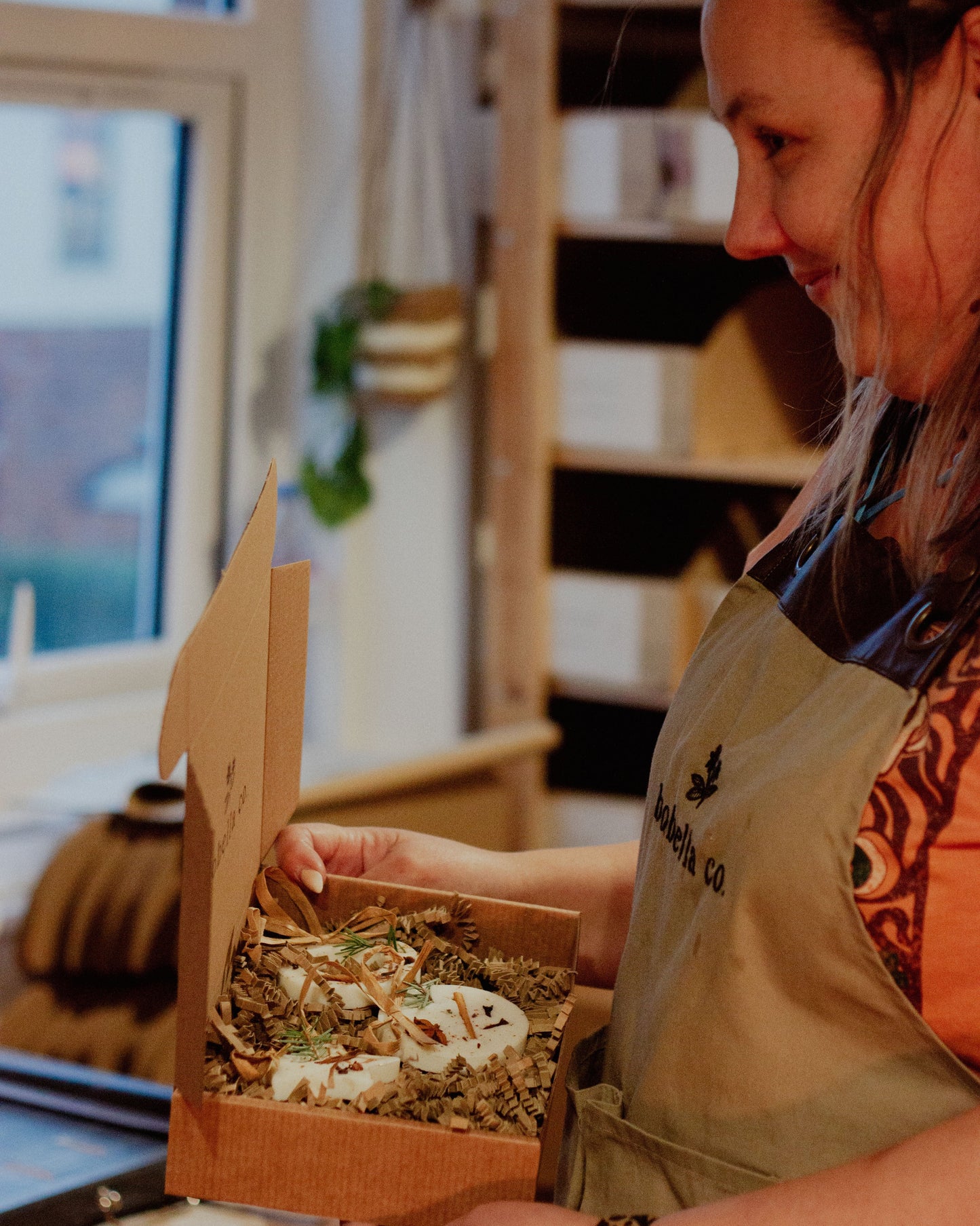 Person holding a box of decorations in a kitchen setting