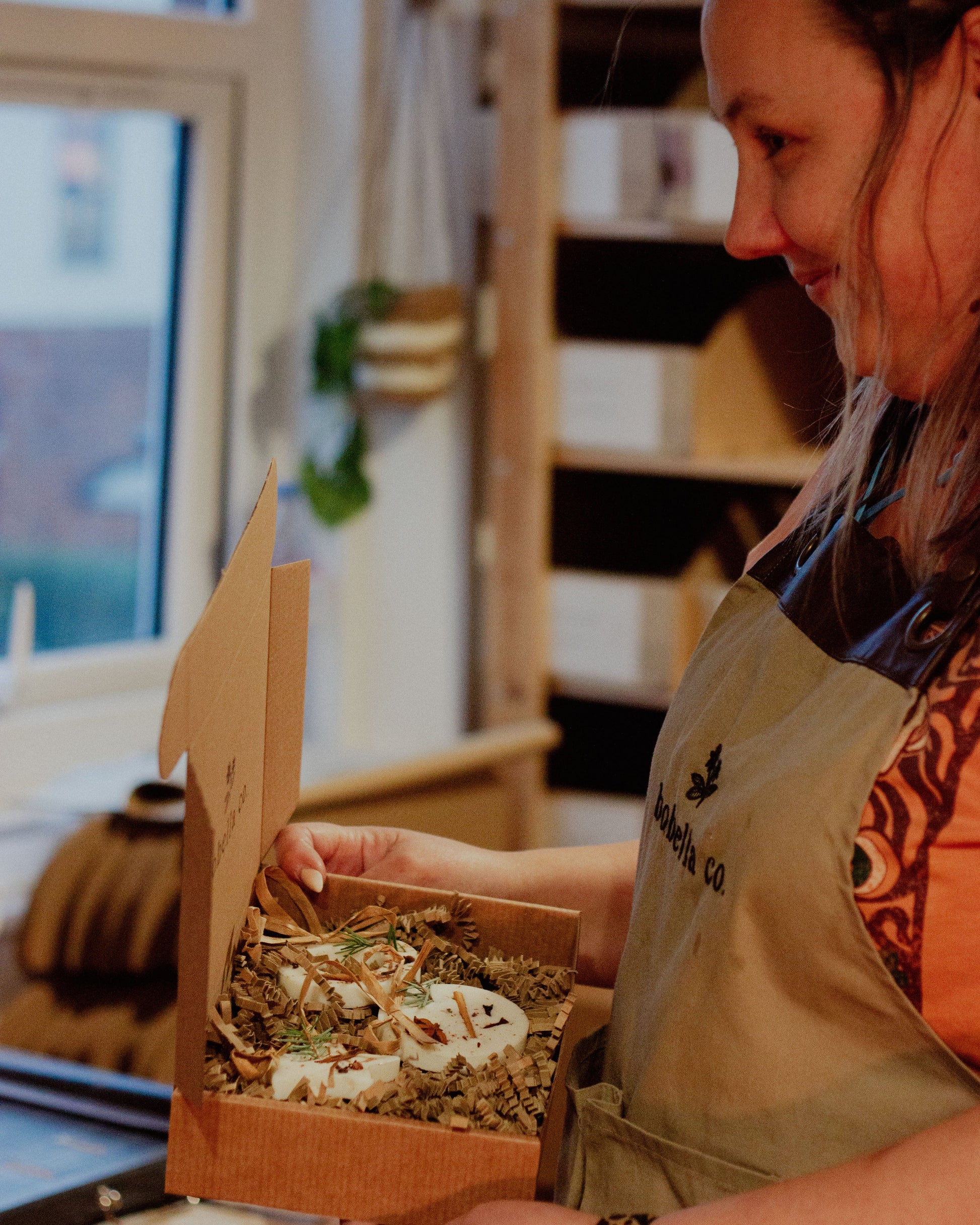 Person holding a box of decorations in a kitchen setting